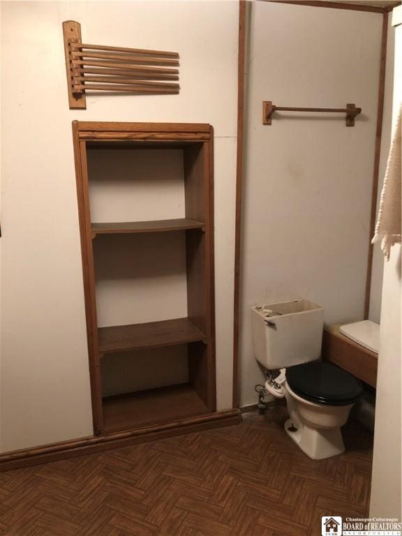 bathroom with parquet floors and toilet