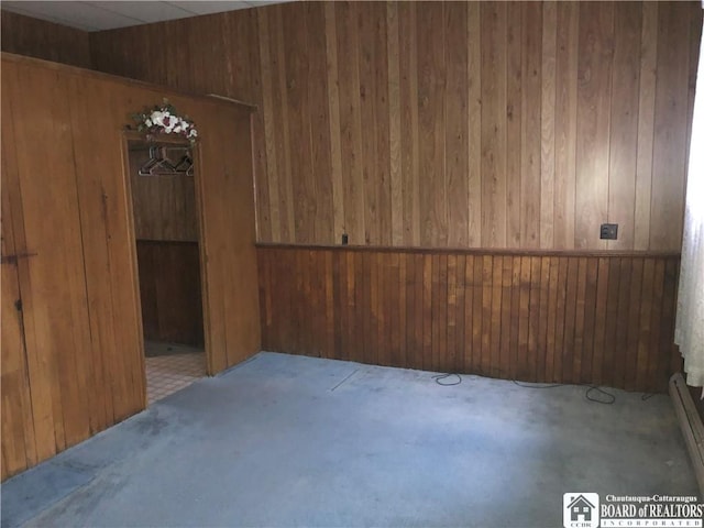 unfurnished room featuring light colored carpet and wooden walls