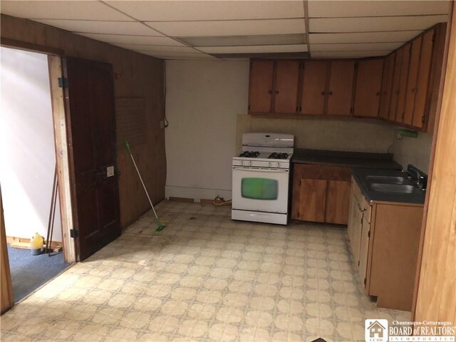 kitchen featuring white range with gas cooktop, a paneled ceiling, and sink