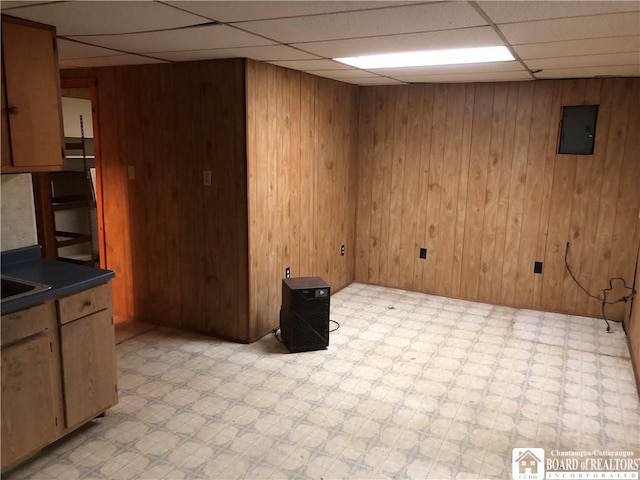 kitchen featuring a paneled ceiling and wooden walls