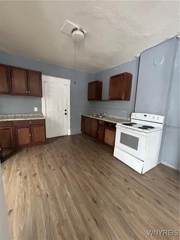 kitchen featuring a textured ceiling, electric stove, and dark hardwood / wood-style floors