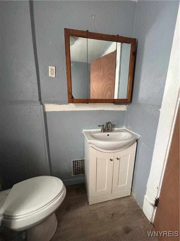 bathroom featuring hardwood / wood-style flooring, vanity, and toilet