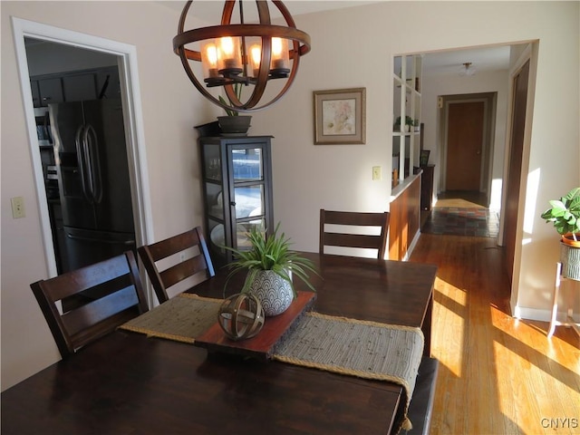 dining space featuring hardwood / wood-style floors and an inviting chandelier