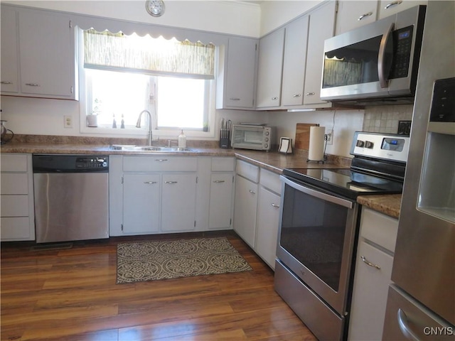 kitchen featuring dark hardwood / wood-style floors, white cabinetry, sink, and appliances with stainless steel finishes