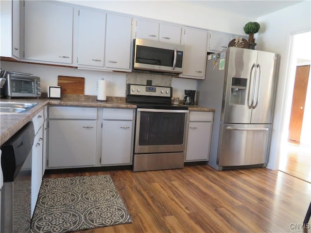 kitchen with stainless steel appliances, dark hardwood / wood-style floors, and sink