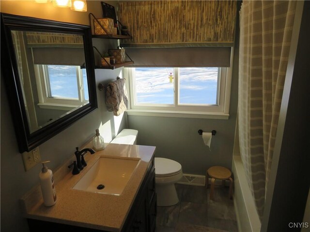 full bathroom with a wealth of natural light, vanity, shower / bath combo, and toilet