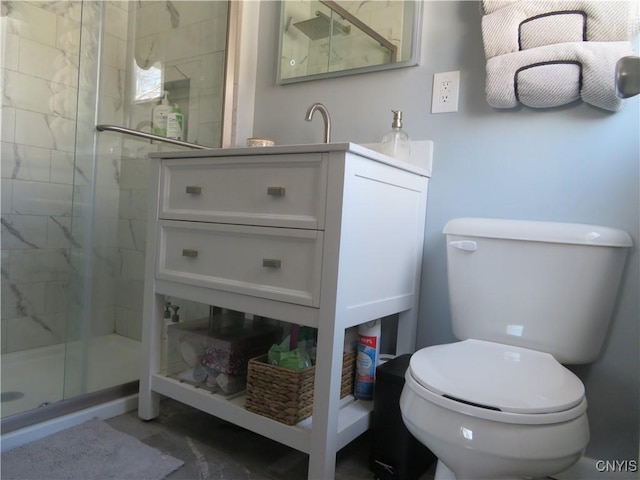 bathroom featuring vanity, toilet, and a shower with door