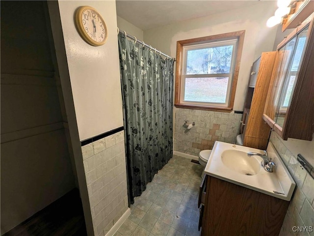 7909 County Route 333, Thurston, NY 14821 - full bathroom featuring wainscoting, vanity, tile walls, and toilet
