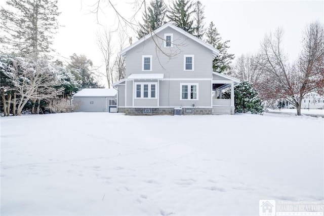 snow covered back of property featuring central air condition unit