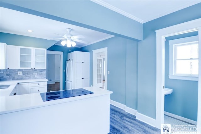 kitchen featuring ceiling fan, tasteful backsplash, kitchen peninsula, black electric stovetop, and white cabinets