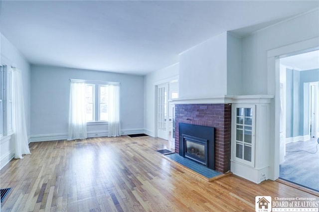 unfurnished living room with light wood-type flooring and a fireplace