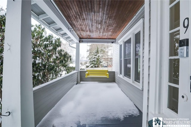 view of snow covered back of property