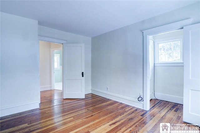 unfurnished room with hardwood / wood-style flooring