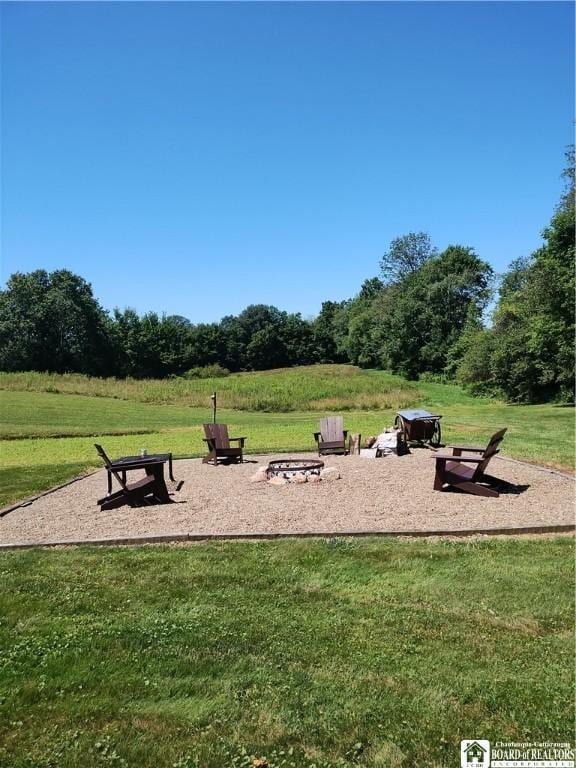 surrounding community featuring a lawn and an outdoor fire pit