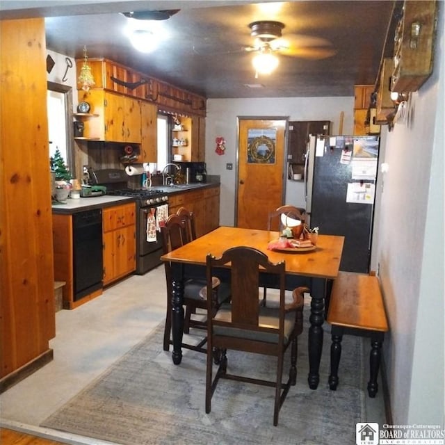 kitchen with ceiling fan, black gas range oven, and stainless steel refrigerator