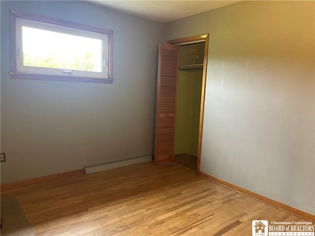 355 New Buffalo Rd, French Creek, NY 14724 - unfurnished bedroom featuring a baseboard heating unit, light wood finished floors, a closet, and baseboards