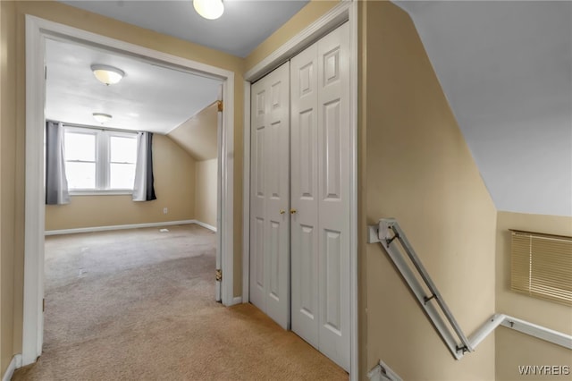 hallway with light colored carpet and vaulted ceiling