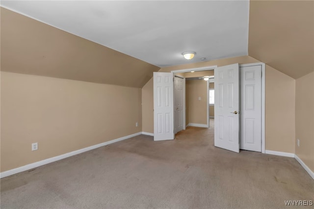 additional living space featuring light carpet and lofted ceiling