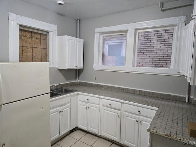 kitchen featuring white cabinetry, sink, and light tile patterned floors