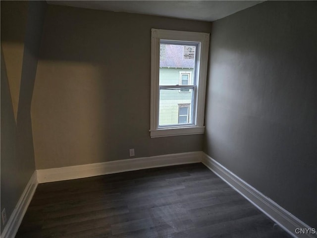 spare room featuring dark hardwood / wood-style flooring and a healthy amount of sunlight