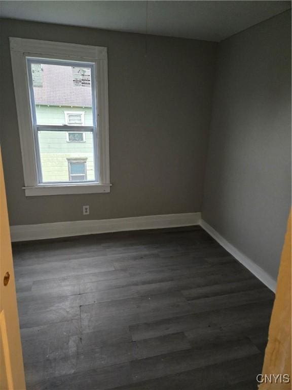 spare room featuring plenty of natural light and dark hardwood / wood-style floors