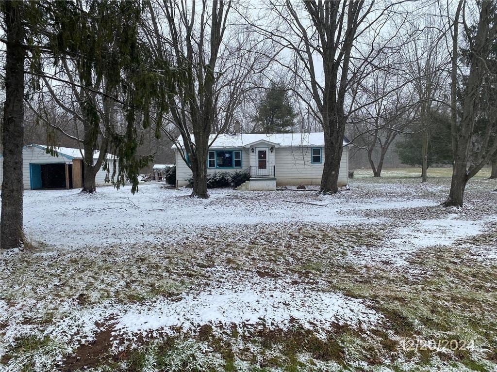 yard layered in snow with an outbuilding