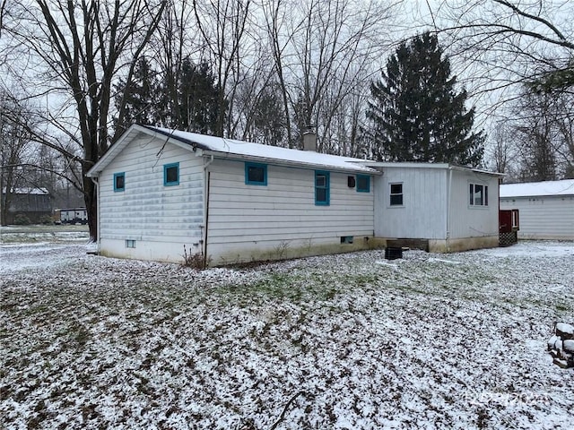 view of snow covered back of property