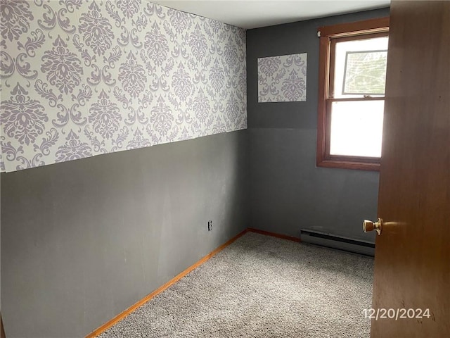 carpeted empty room with baseboard heating