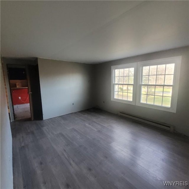 unfurnished room with a baseboard radiator and dark hardwood / wood-style floors