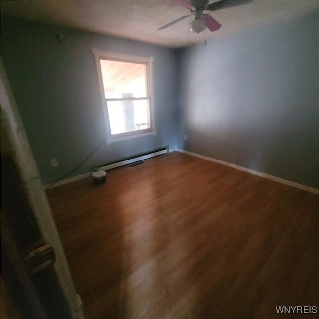 unfurnished room featuring hardwood / wood-style floors, ceiling fan, and a baseboard heating unit