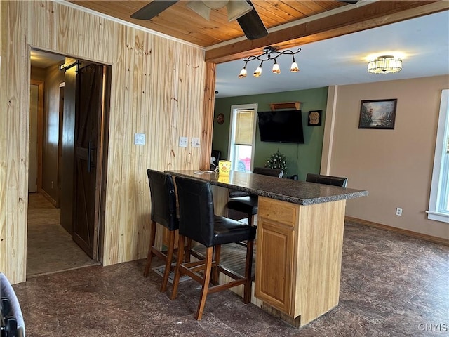 bar with wood ceiling, ceiling fan, wooden walls, light brown cabinets, and pendant lighting