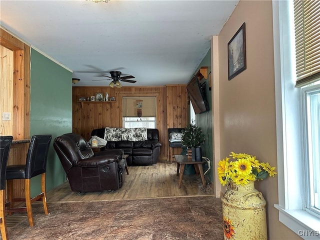 living room featuring hardwood / wood-style floors, ceiling fan, and wood walls