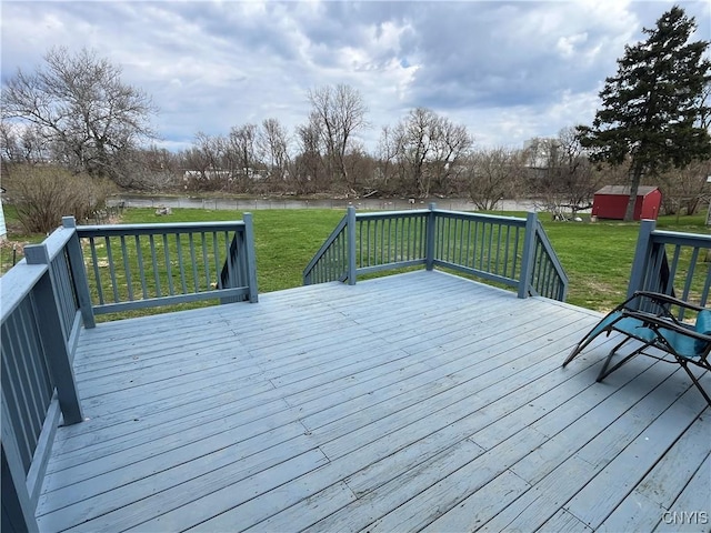 57 Liberty St, Adams, NY 13605 - wooden deck featuring an outdoor structure, a lawn, a storage shed, and a water view