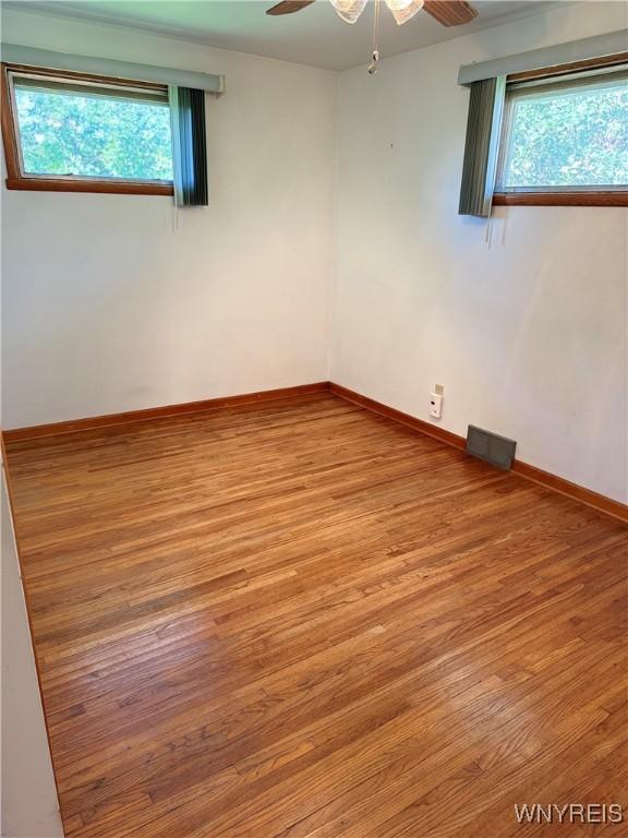 spare room with ceiling fan, light hardwood / wood-style floors, and a healthy amount of sunlight