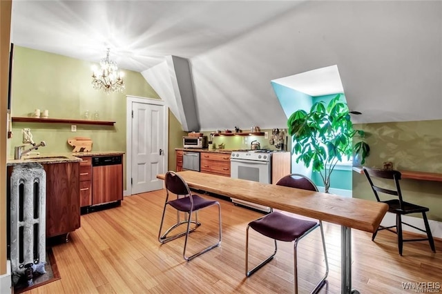 interior space featuring dishwashing machine, vaulted ceiling, sink, light hardwood / wood-style flooring, and a chandelier