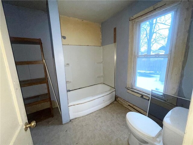 bathroom featuring a healthy amount of sunlight, shower / bathtub combination, and toilet