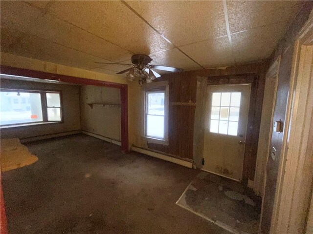 empty room with a healthy amount of sunlight, ceiling fan, and a baseboard radiator