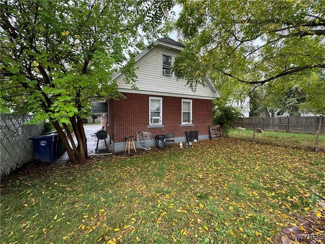 rear view of house with a yard and cooling unit