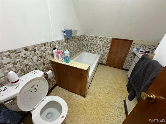 bathroom with a tub, tile walls, and toilet