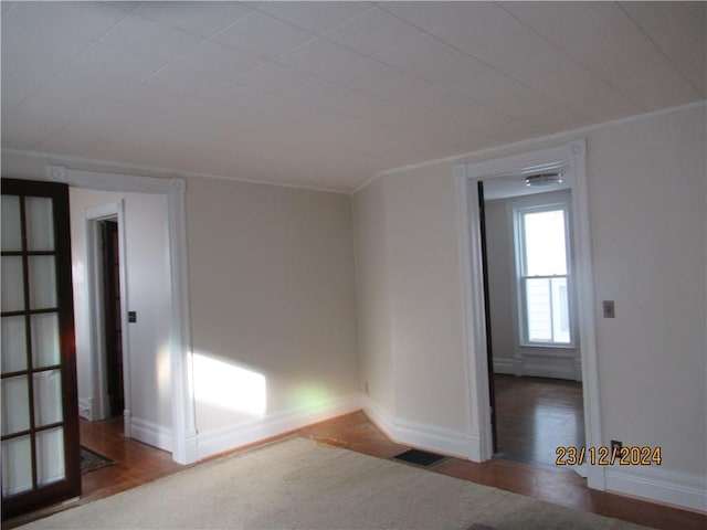 unfurnished room featuring hardwood / wood-style floors and crown molding