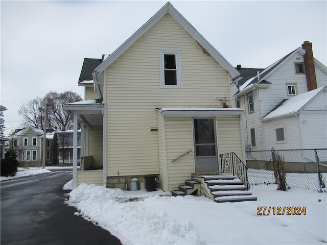 view of snow covered rear of property