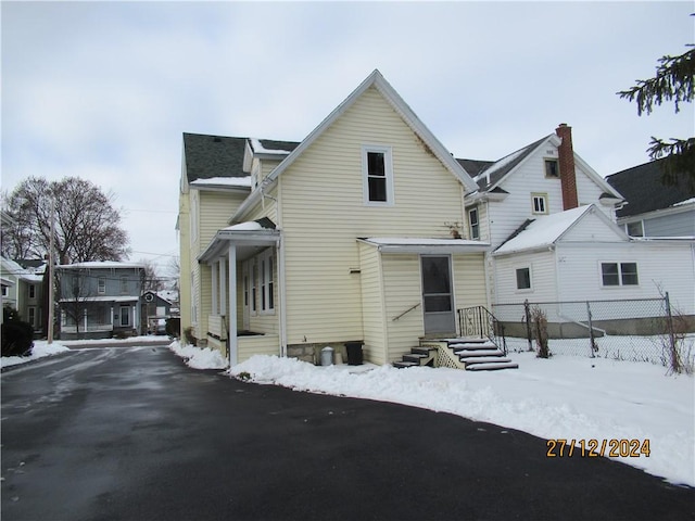 view of snow covered back of property