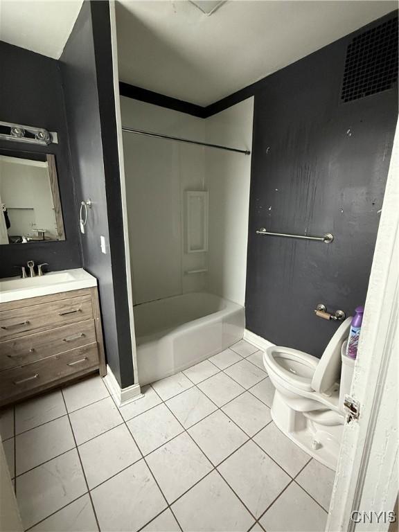 full bathroom featuring washtub / shower combination, tile patterned flooring, vanity, and toilet