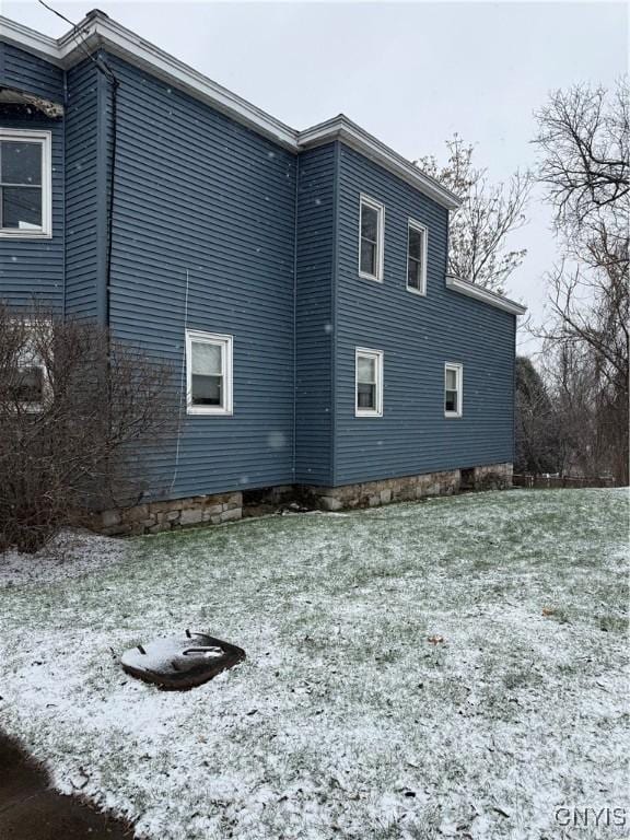 snow covered property with a lawn