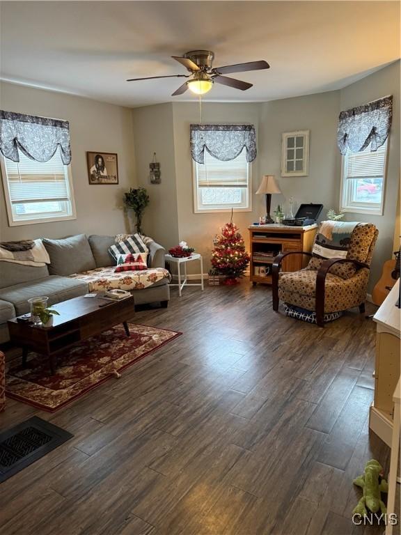 living room featuring ceiling fan and dark hardwood / wood-style flooring