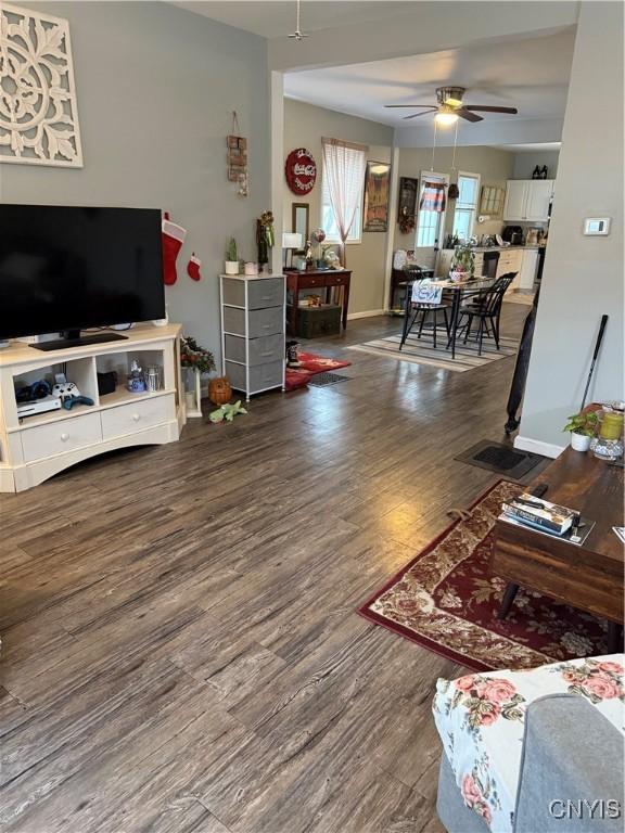 living room featuring ceiling fan and dark wood-type flooring