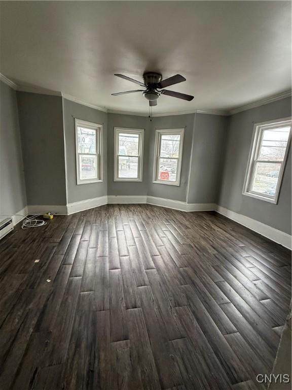 unfurnished room with ceiling fan, dark hardwood / wood-style floors, and ornamental molding