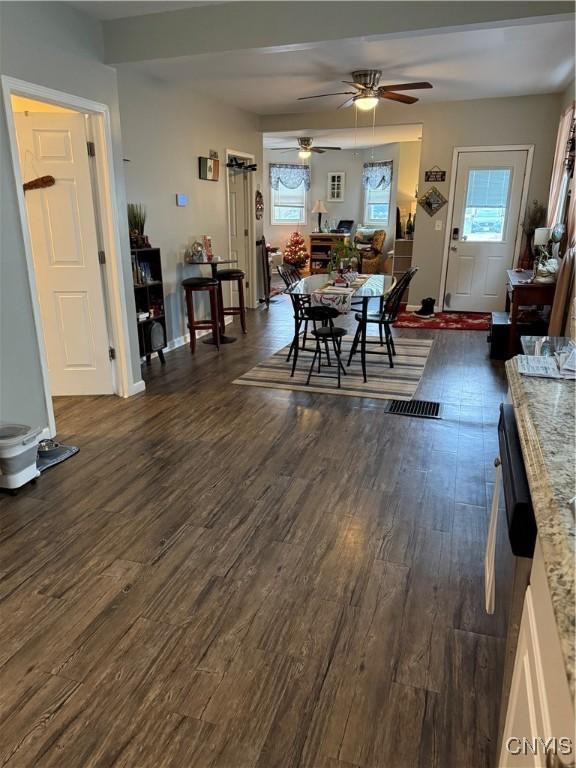 dining space with dark hardwood / wood-style flooring and ceiling fan