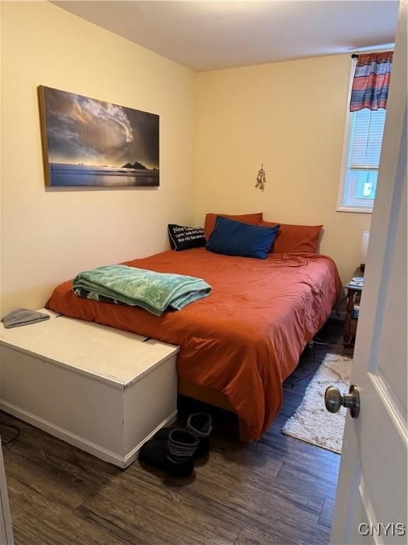 bedroom with dark wood-type flooring