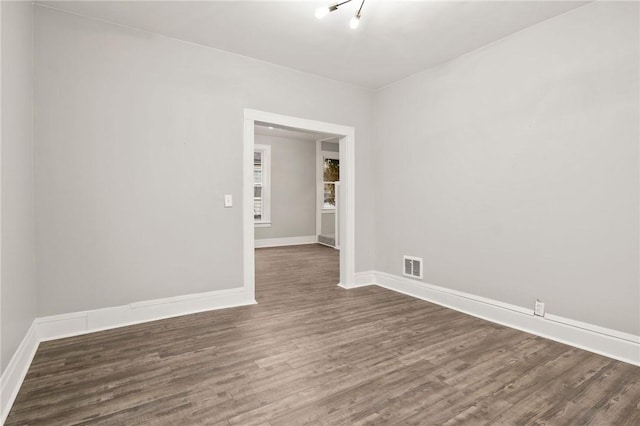 unfurnished room featuring dark wood-type flooring